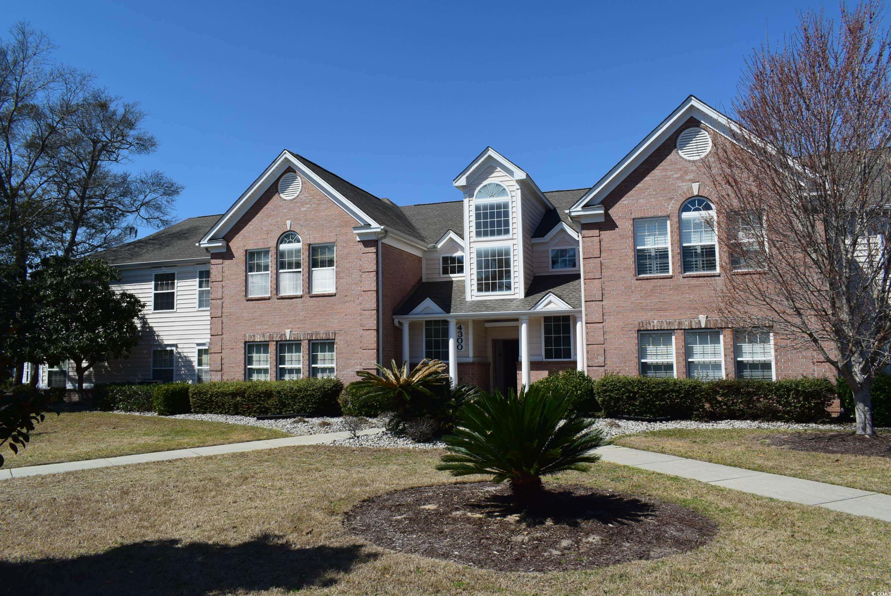 View of front facade featuring brick siding and a front yard
