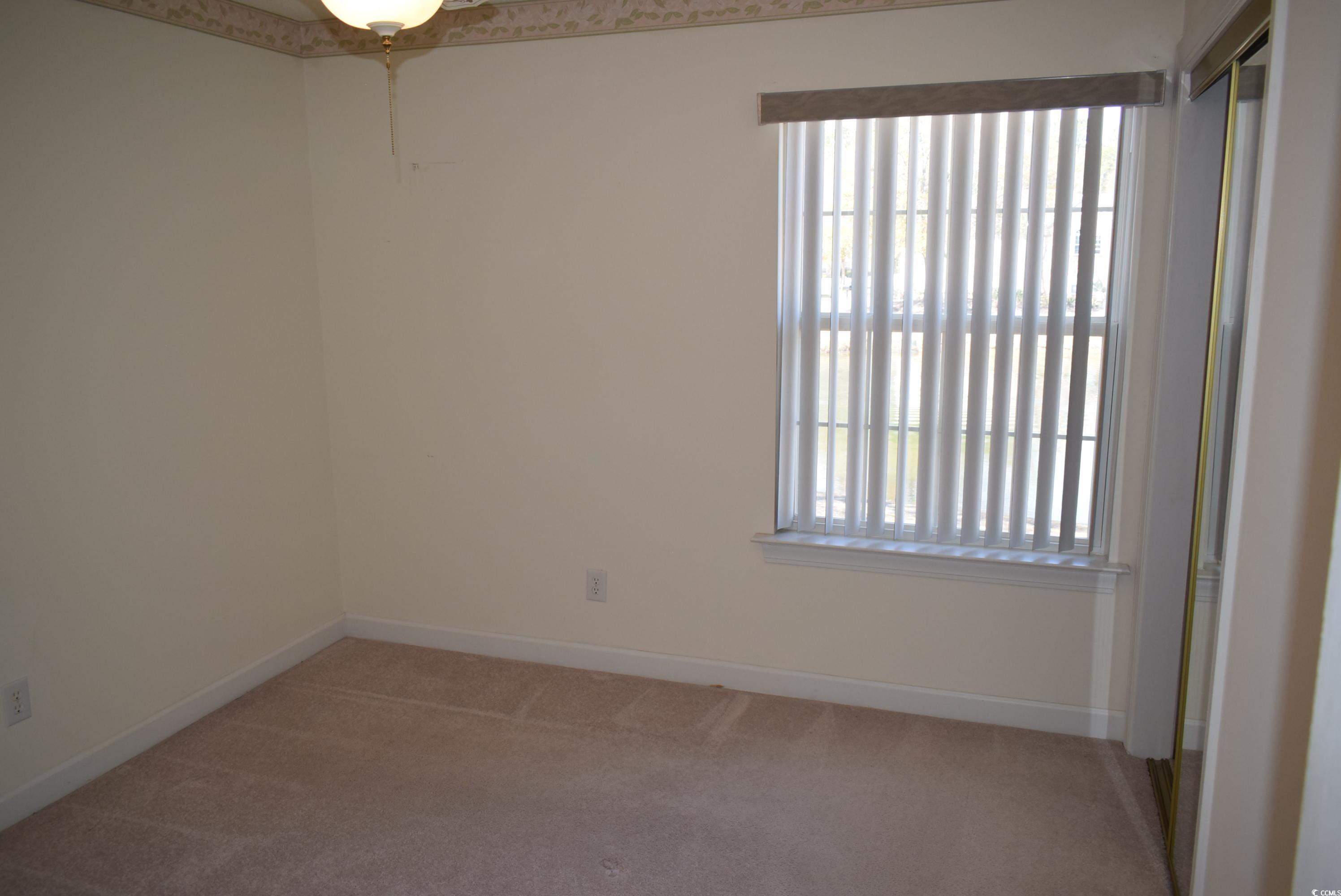 4300 Lotus Court, Unit G Murrells Inlet, SC 29576 - Photo 13 of 27 Empty room featuring light colored carpet, baseboards, and a healthy amount of sunlight