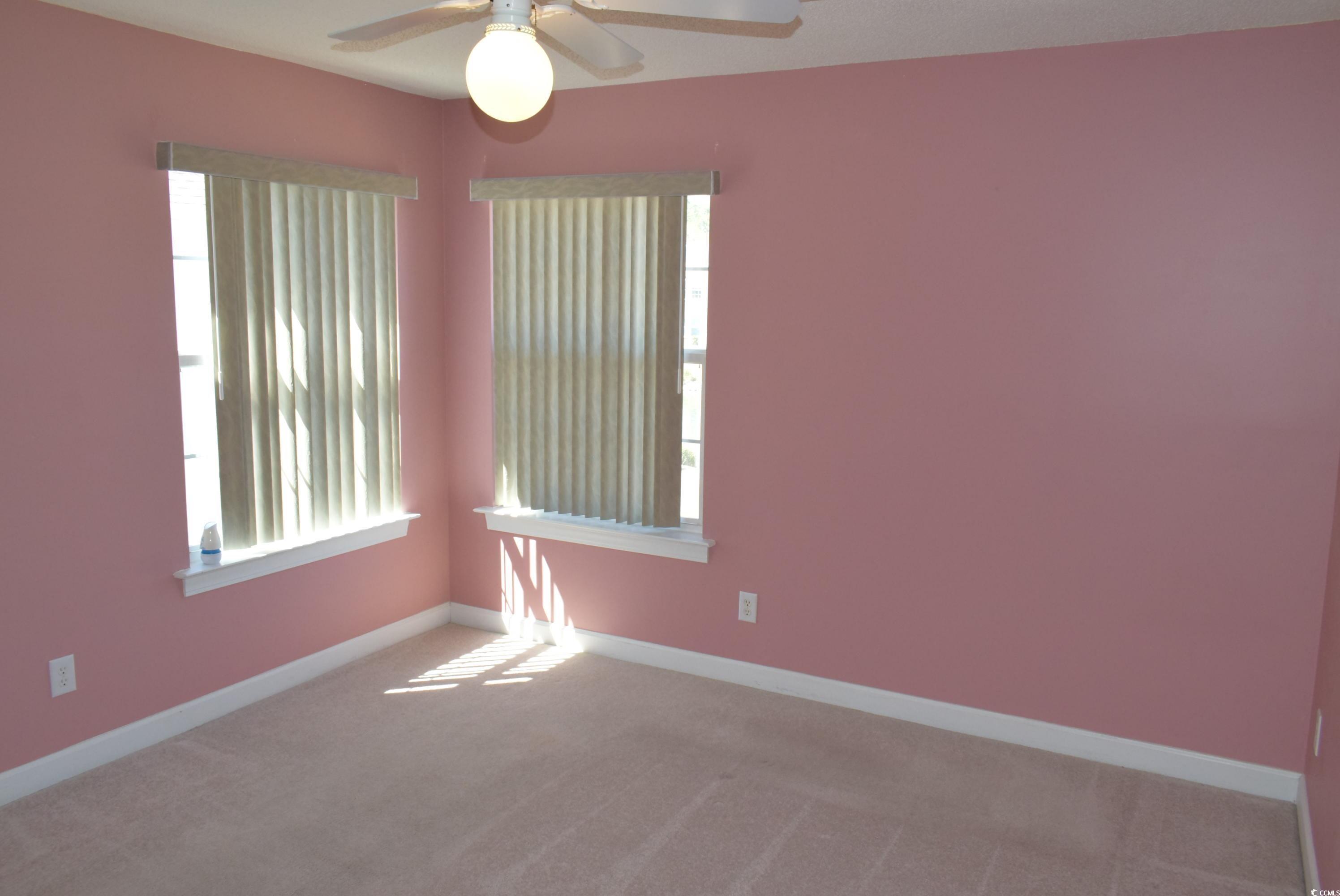 4300 Lotus Court, Unit G Murrells Inlet, SC 29576 - Photo 15 of 27 Carpeted spare room featuring baseboards, a healthy amount of sunlight, and a ceiling fan