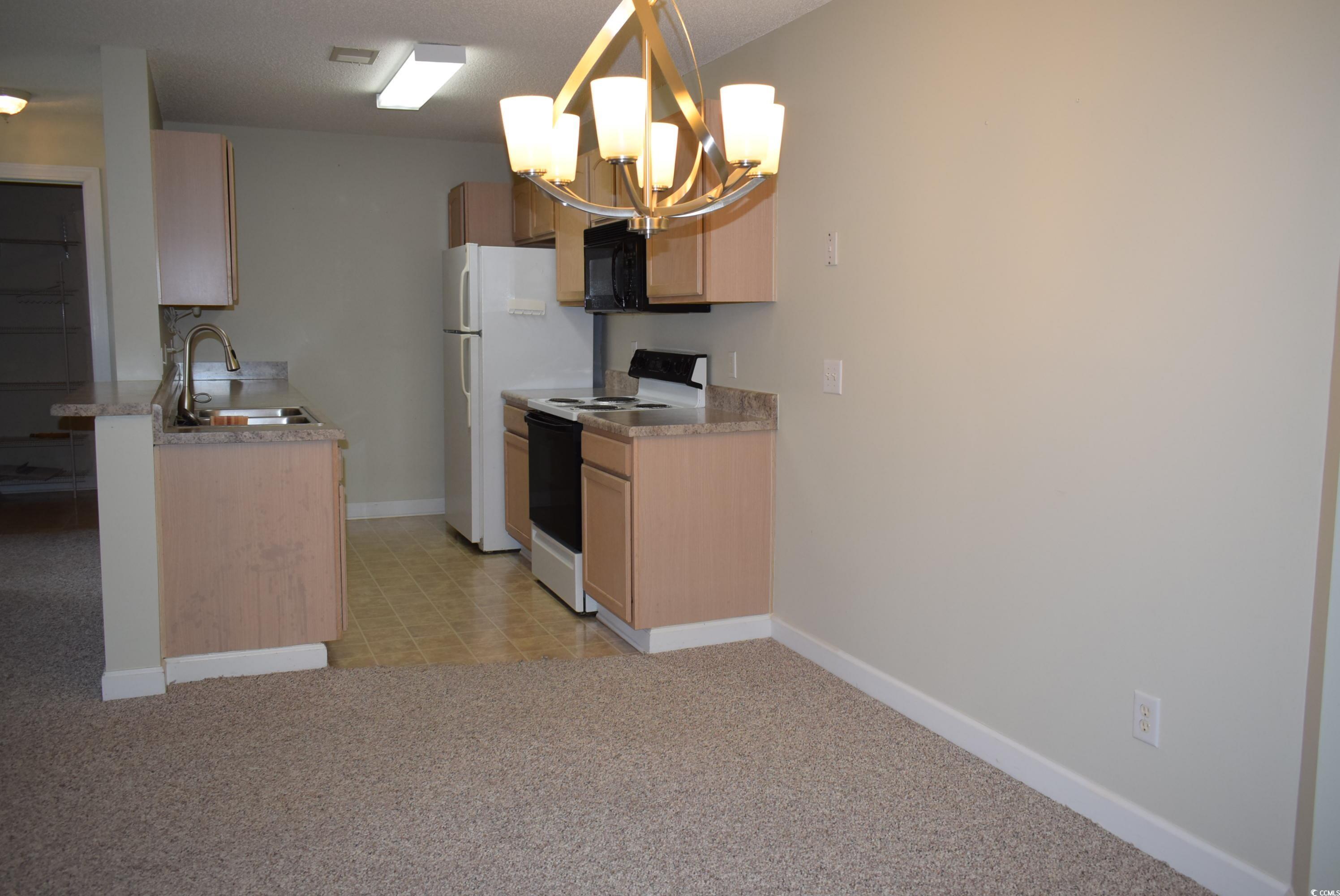 4300 Lotus Court, Unit G Murrells Inlet, SC 29576 - Photo 20 of 27 Kitchen featuring baseboards, light carpet, range with electric stovetop, an inviting chandelier, and a sink