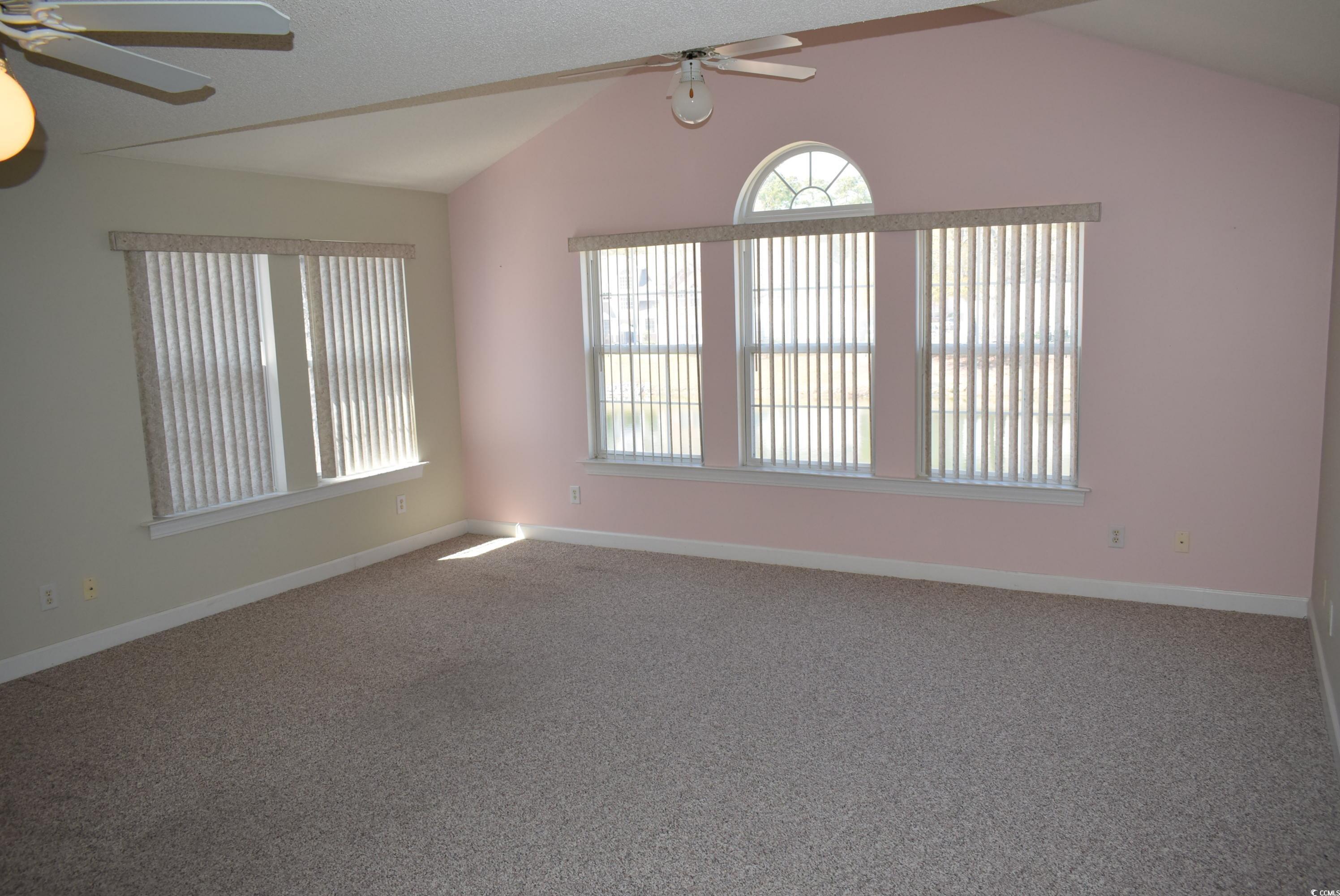 4300 Lotus Court, Unit G Murrells Inlet, SC 29576 - Photo 2 of 27 Carpeted spare room featuring baseboards, lofted ceiling, and a ceiling fan