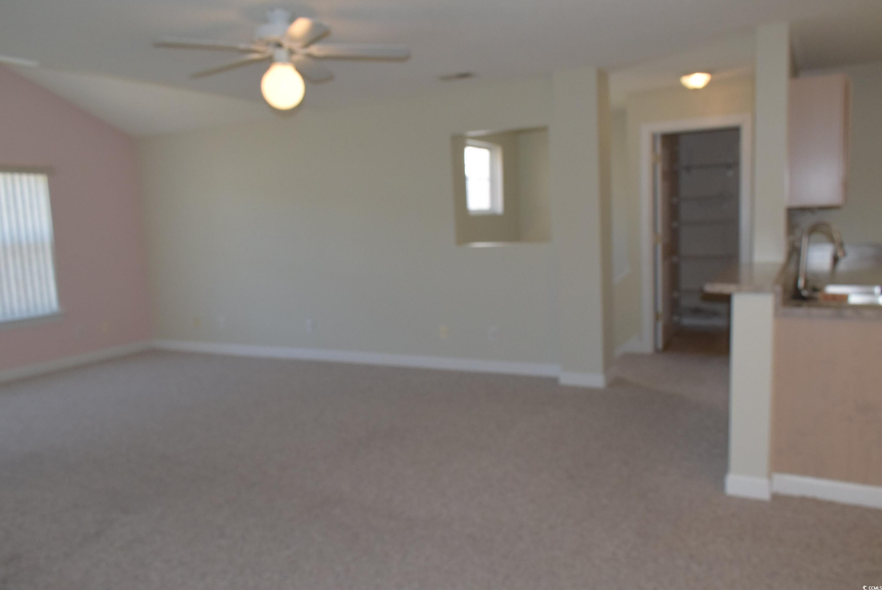 4300 Lotus Court, Unit G Murrells Inlet, SC 29576 - Photo 21 of 27 Unfurnished living room with light carpet, baseboards, a ceiling fan, and a sink