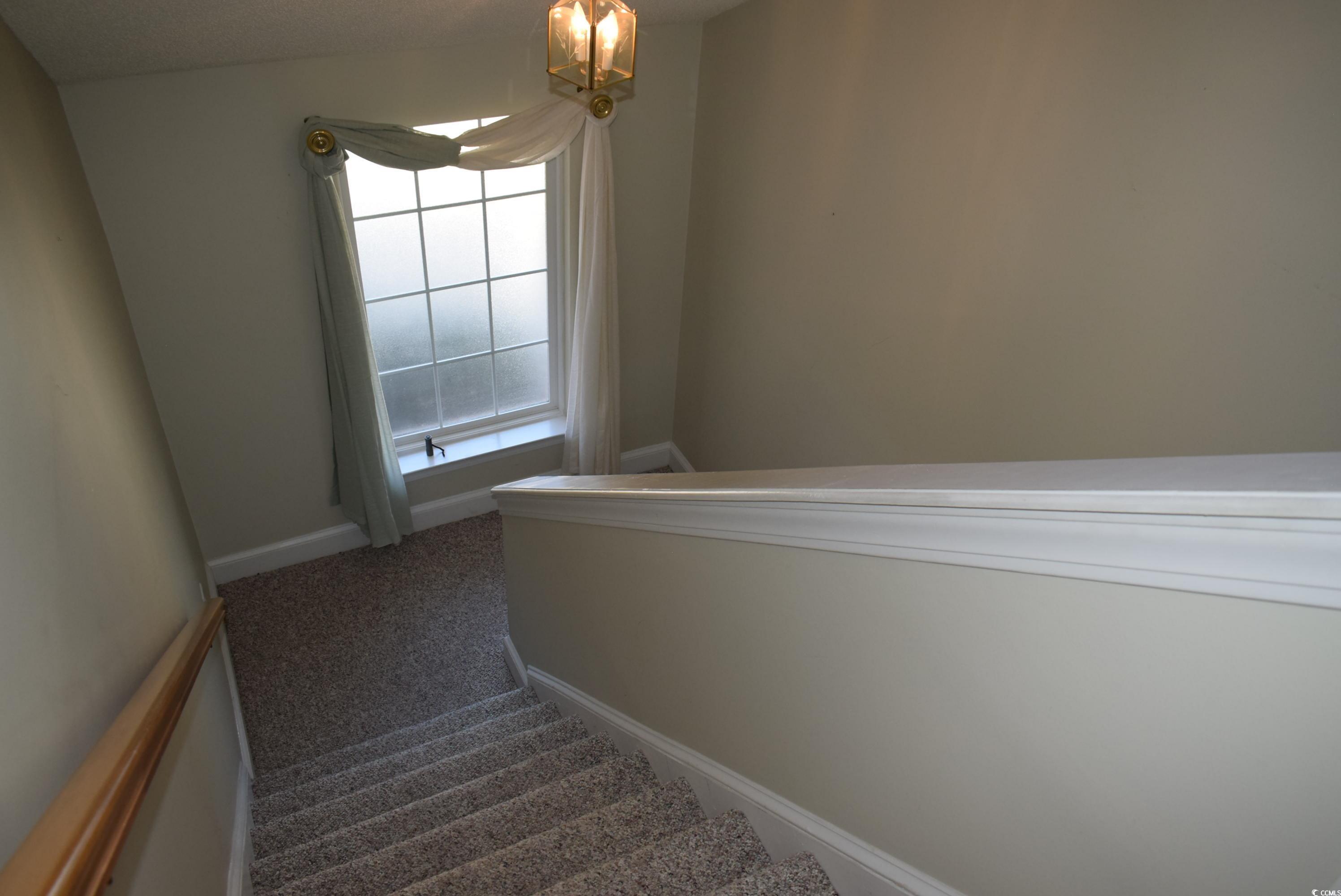 4300 Lotus Court, Unit G Murrells Inlet, SC 29576 - Photo 4 of 27 Stairway with an inviting chandelier, carpet, and baseboards