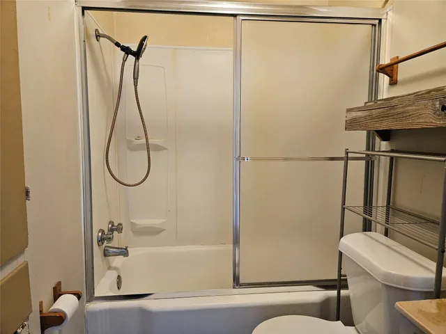a bathroom with a shower a toilet and a shower