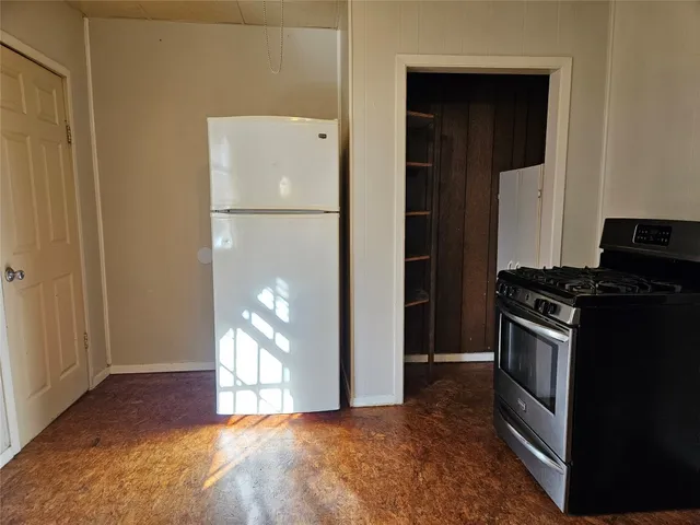 a view of a kitchen with a stove refrigerator and window