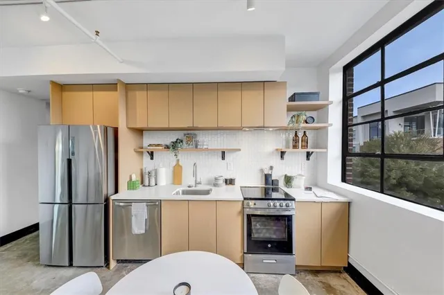 a kitchen with stainless steel appliances a refrigerator sink and cabinets