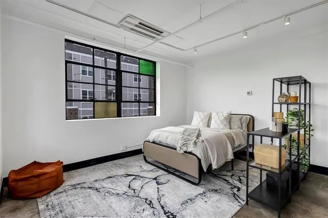 a bedroom with a bed wooden floor and window