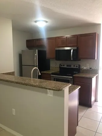 a kitchen with stainless steel appliances granite countertop a sink and a stove
