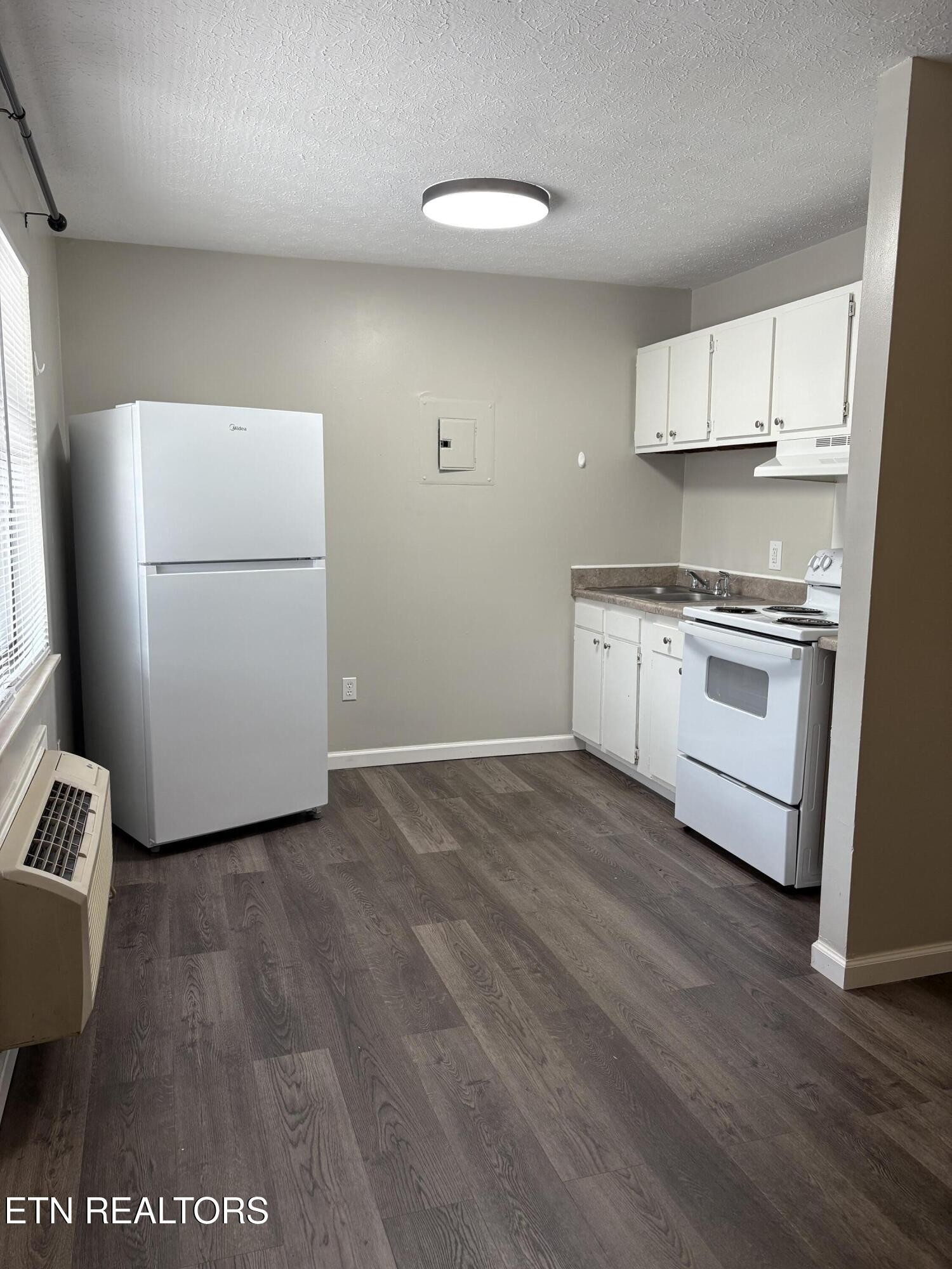 128 South 3rd Street, Unit 23 Kingston, TN 37763 - Photo 2 of 6 a kitchen with a refrigerator sink stove and cabinets