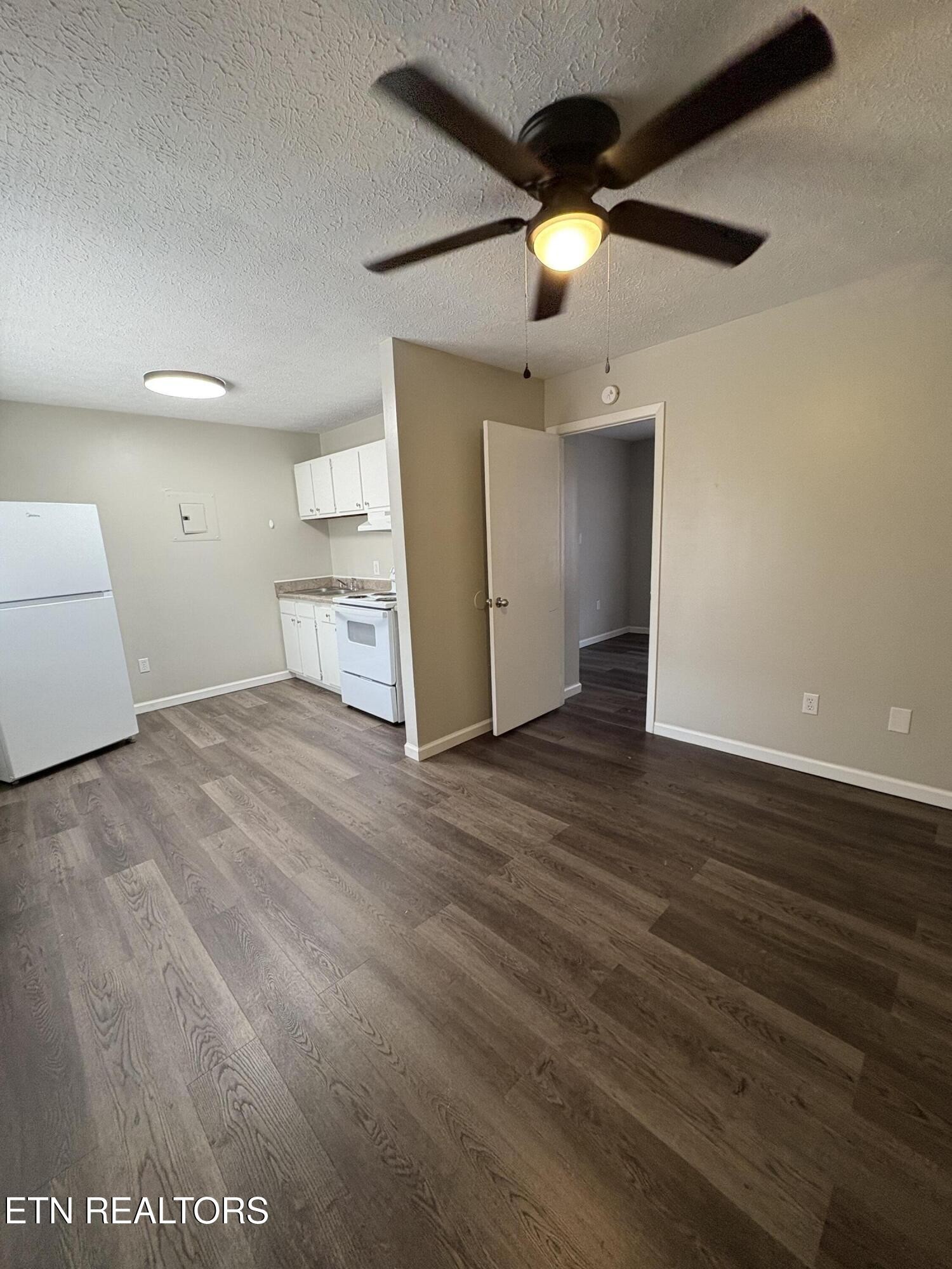 128 South 3rd Street, Unit 23 Kingston, TN 37763 - Photo 3 of 6 a view of a livingroom with a ceiling fan wooden floor and window