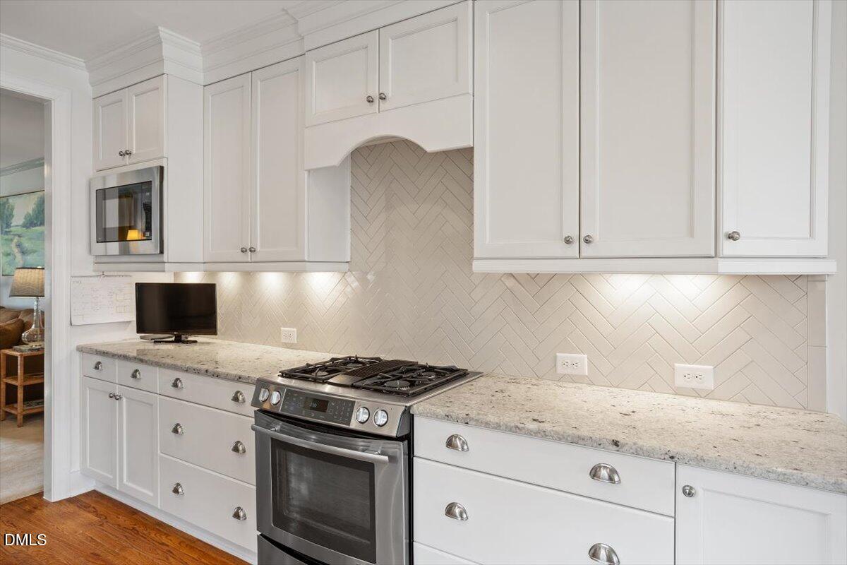 2104 Reaves Drive Raleigh, NC 27608 - Photo 11 of 29 a kitchen with granite countertop white cabinets and stainless steel appliances