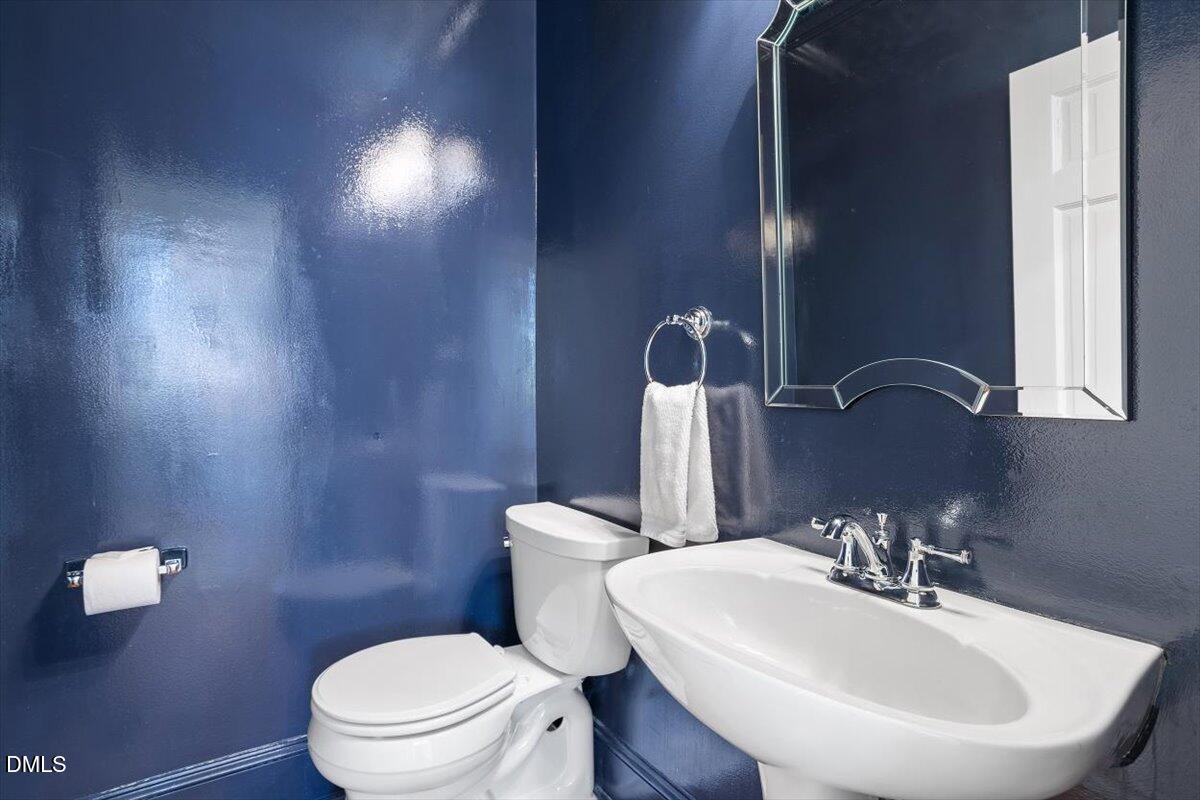 2104 Reaves Drive Raleigh, NC 27608 - Photo 16 of 29 a bathroom with a sink a toilet and mirror