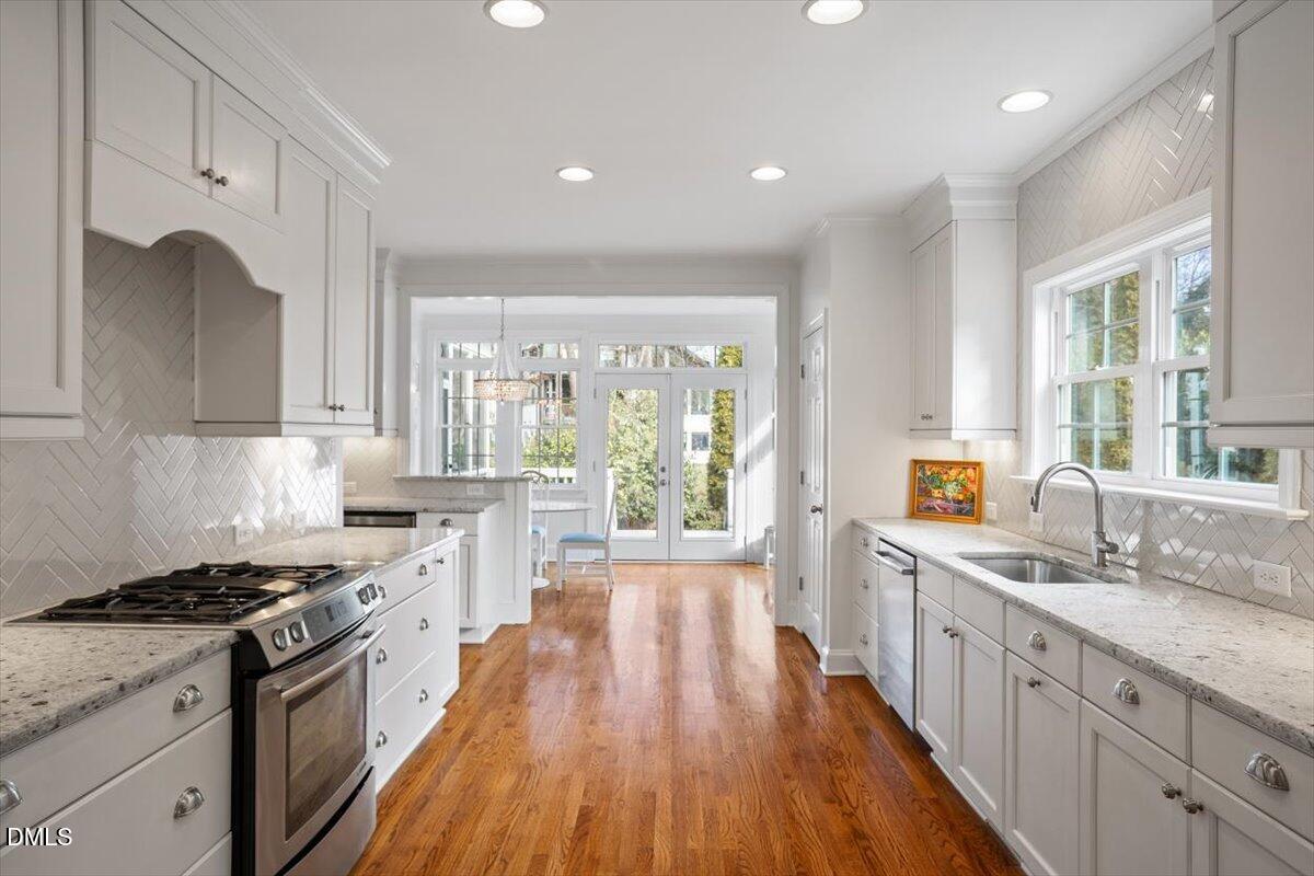 2104 Reaves Drive Raleigh, NC 27608 - Photo 9 of 29 a large kitchen with stainless steel appliances granite countertop a lot of counter space and wooden floors
