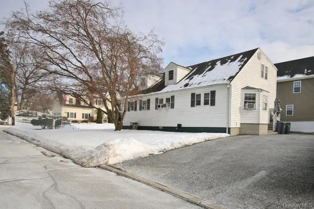 a view of a house with a yard covered in snow