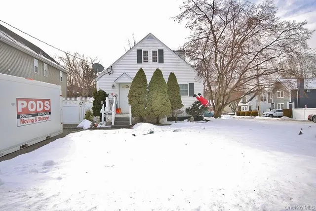 a front view of a building with snow on the road