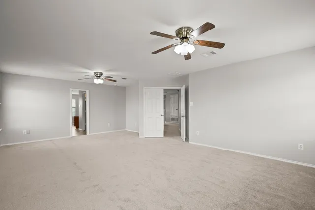 a view of an empty room with a ceiling fan