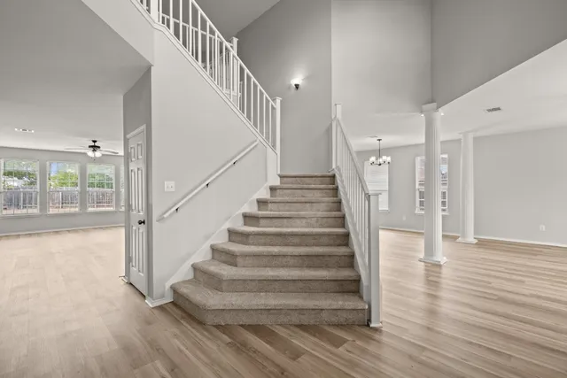 a view of staircase with white walls and wooden floor