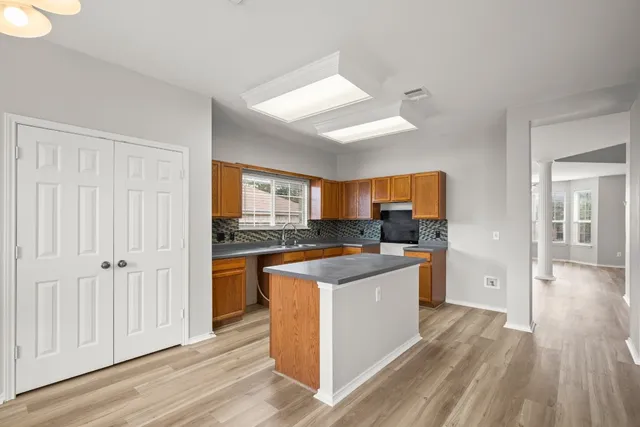 a kitchen with cabinets and wooden floor