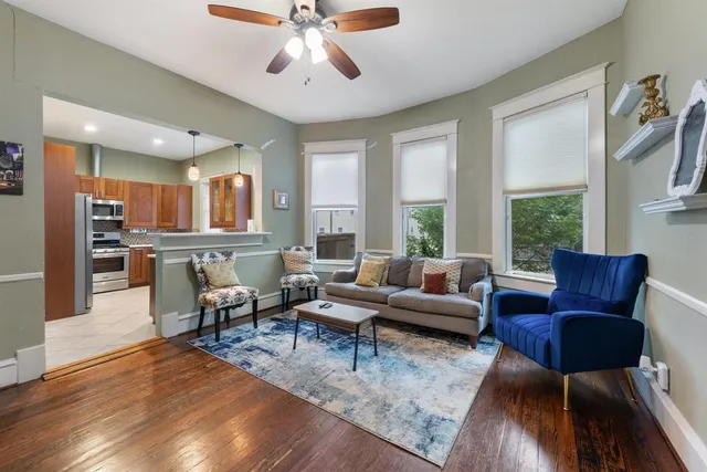 a living room with furniture wooden floor and a large window