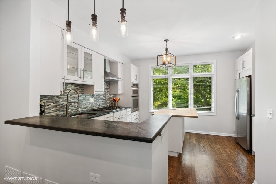 1455 South Indiana Avenue Chicago, IL 60605 - Photo 8 of 27 a view of a kitchen with granite countertop a sink stainless steel appliances cabinets and a wooden floor
