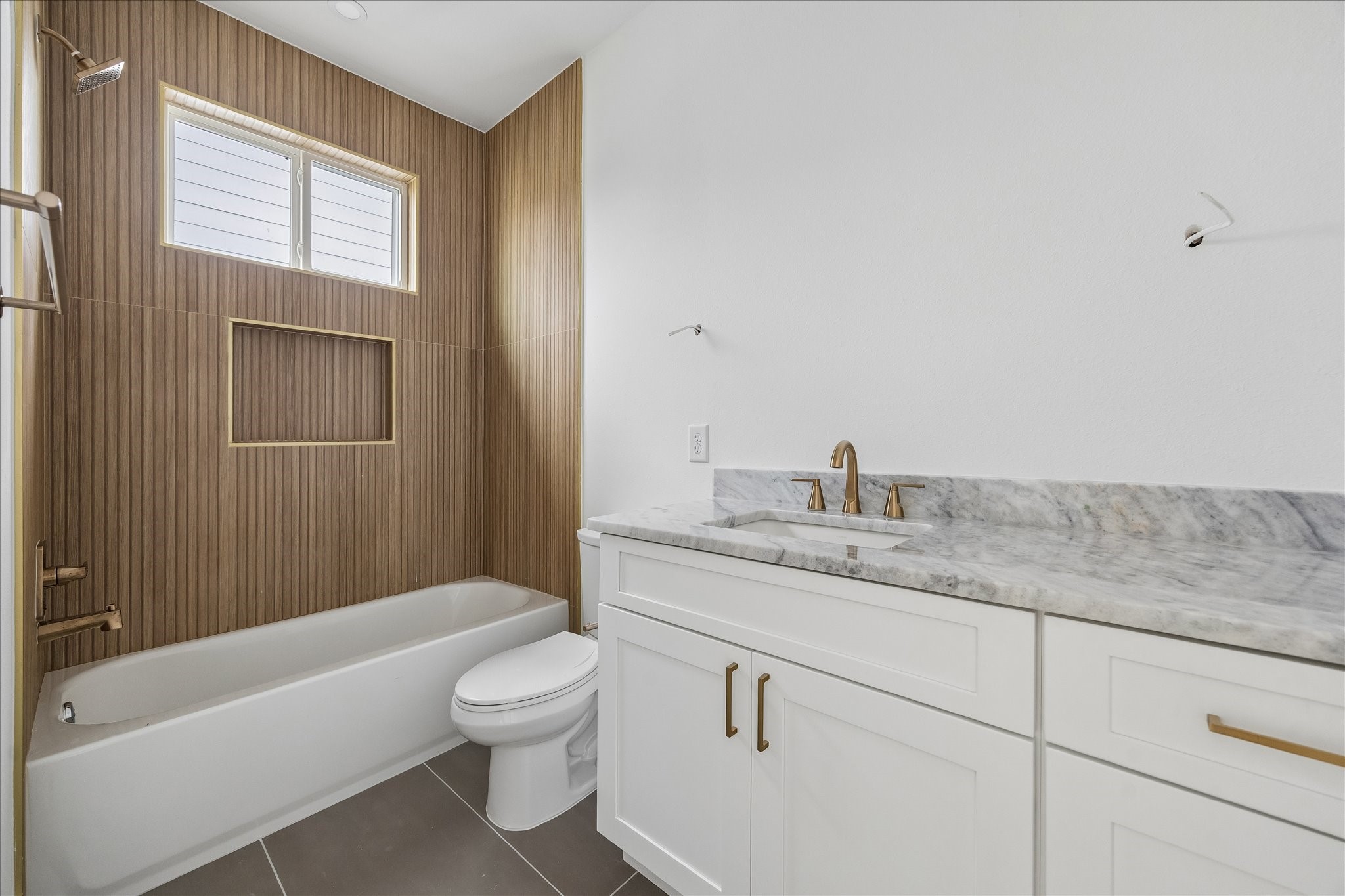 1034 West 17th Street, Unit B Houston, TX 77008 - Photo 16 of 25 Ensuite bath for the third bedroom features dolomite countertops, wood-look tile, and a shower/tub combo.