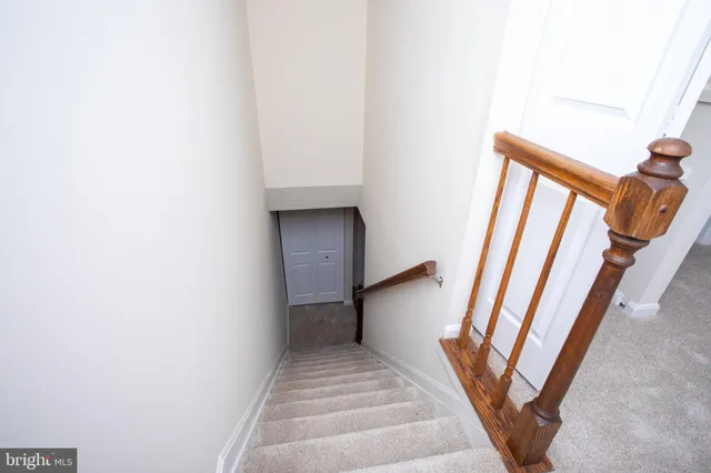 a view of staircase with white walls and railing