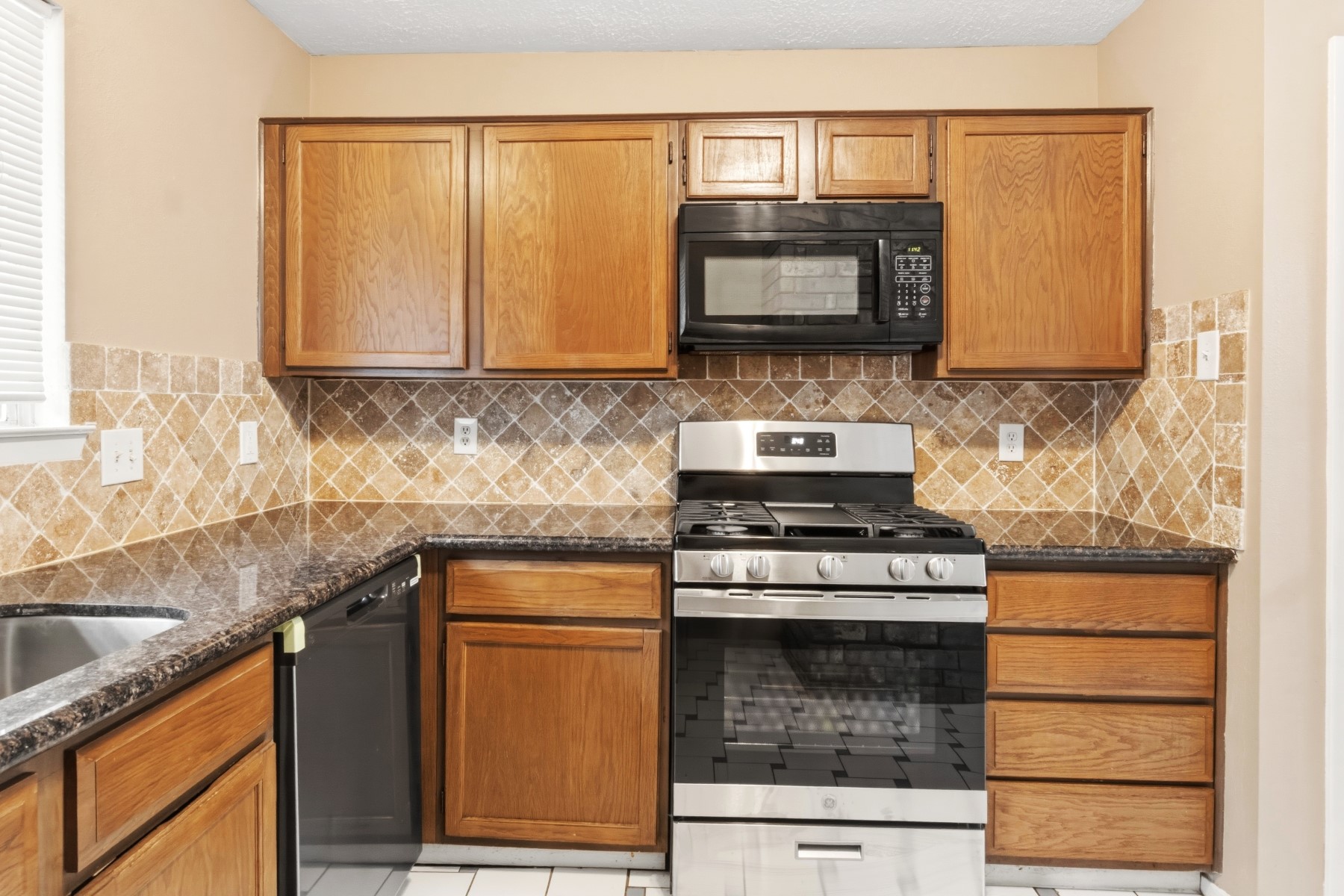 2531 North Spring Drive Spring, TX 77373 - Photo 10 of 24 a kitchen with granite countertop a stove sink and cabinets