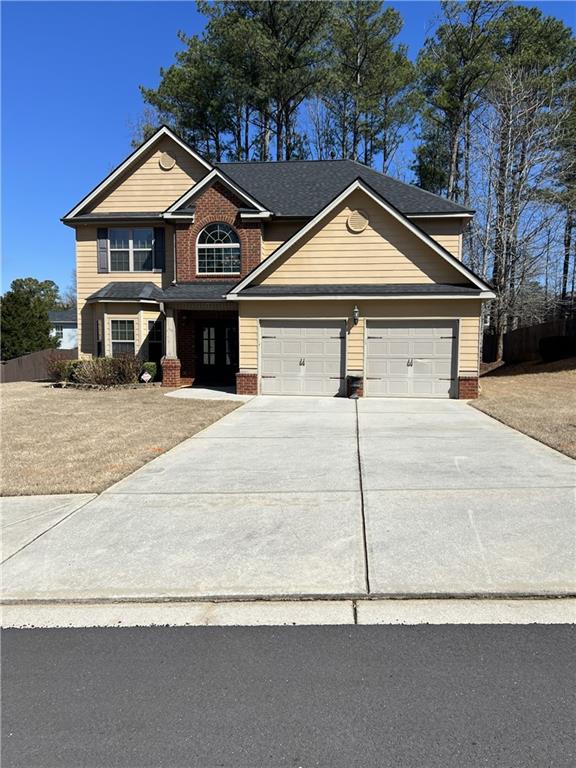 a front view of a house with a yard and garage