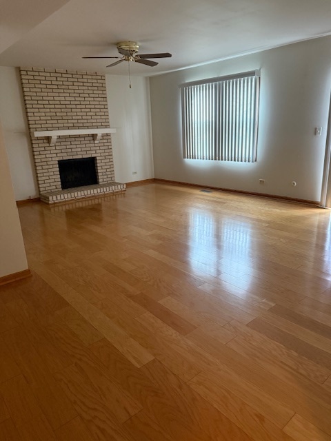 1575 Buckthorn Drive Hoffman Estates, IL 60192 - Photo 6 of 6 an empty room with wooden floor fireplace and windows