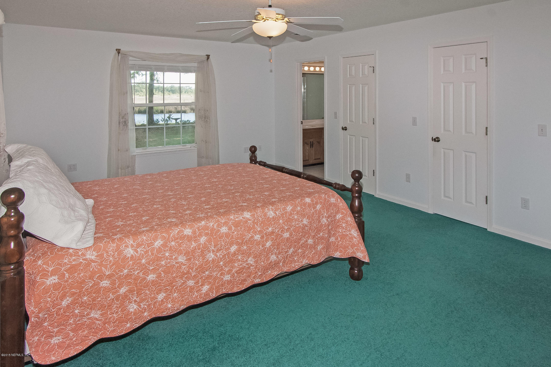 75109 Edwards Road Yulee, FL 32097 - Photo 11 of 30 a bed sitting in a spacious bedroom next to a window