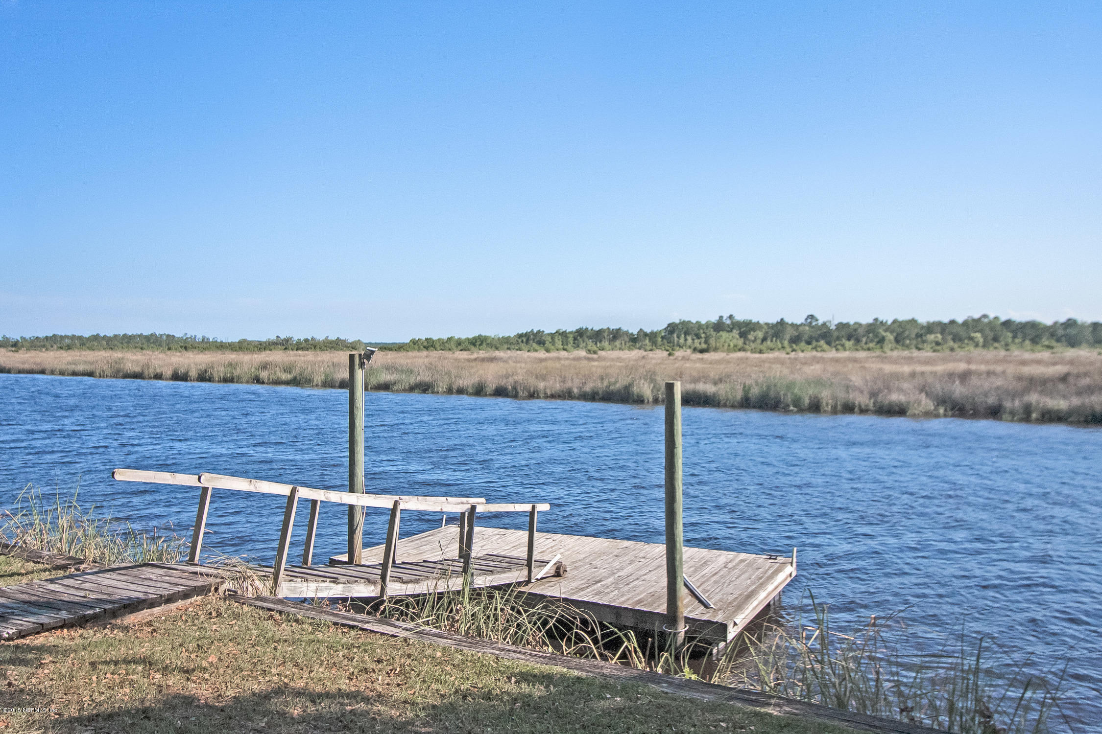 75109 Edwards Road Yulee, FL 32097 - Photo 24 of 30 a wooden bench sitting next to a lake