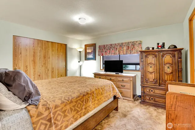 a bedroom with a bed and flat screen tv