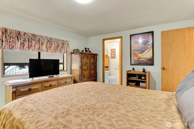 a bedroom with a bed and a flat screen tv