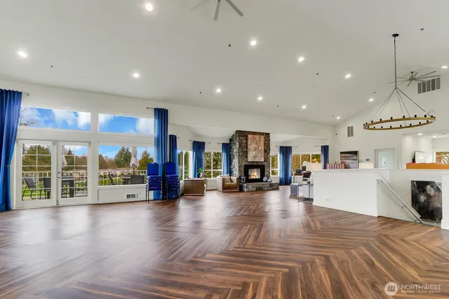 a view of a living room a dining room wooden floor and a large window