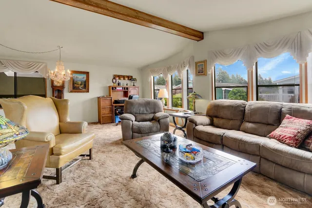a living room with furniture a large window and a table