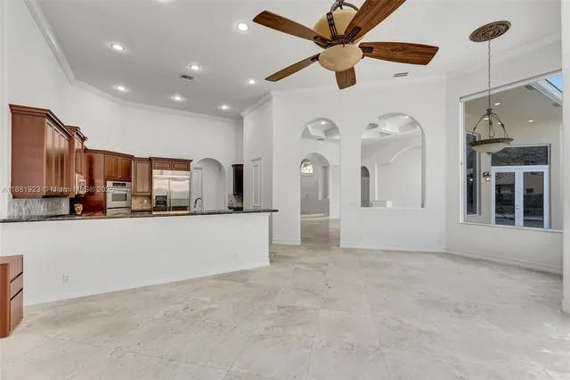 a view of a living room and kitchen with stainless steel appliances