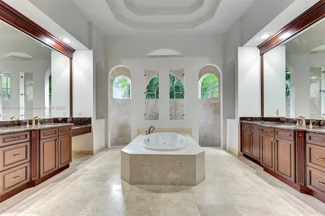 a bathroom with a tub a sink a mirror and a shower