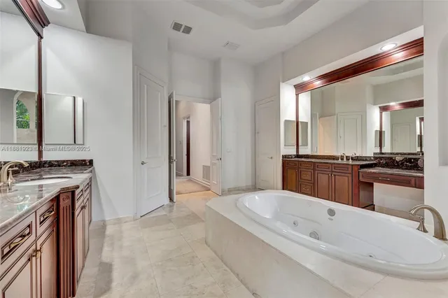 a bathroom with a granite countertop shower a sink and a window