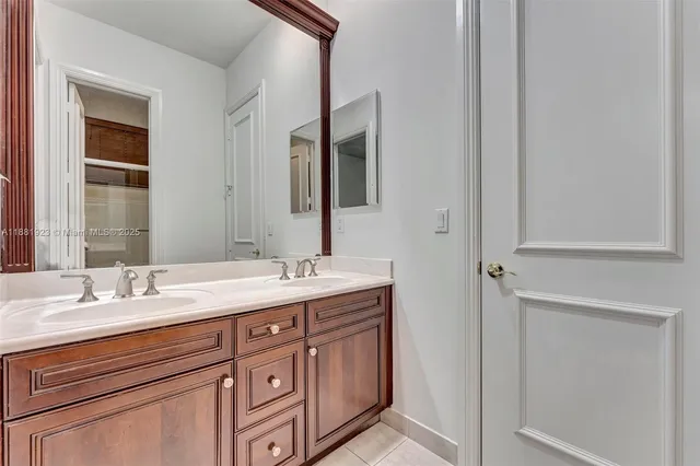 a view of a hallway with wooden floor and a bathroom