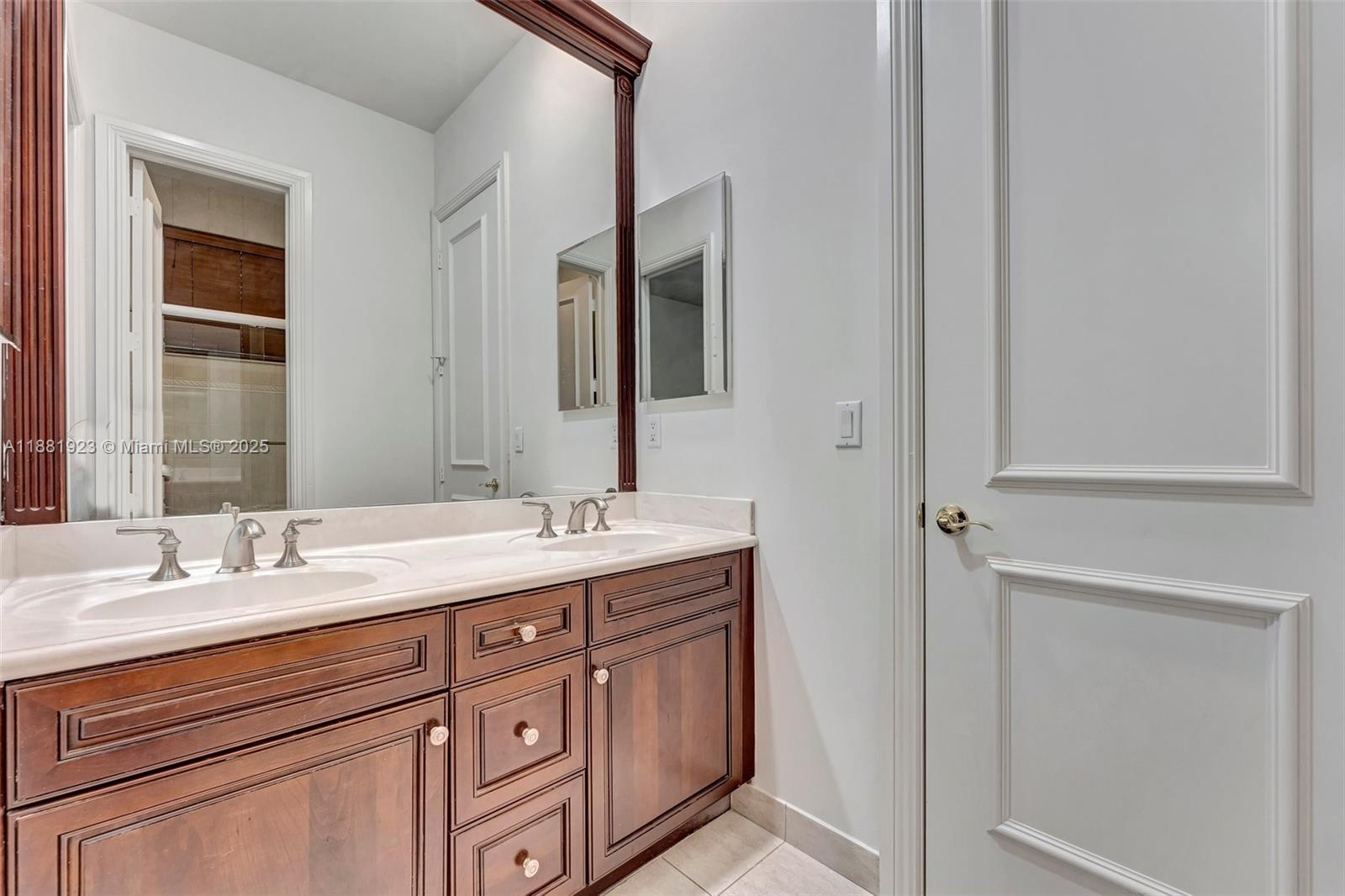 3203 West Stonebrook Circle Davie, FL 33330 - Photo 33 of 51 a bathroom with a double vanity sink and a mirror