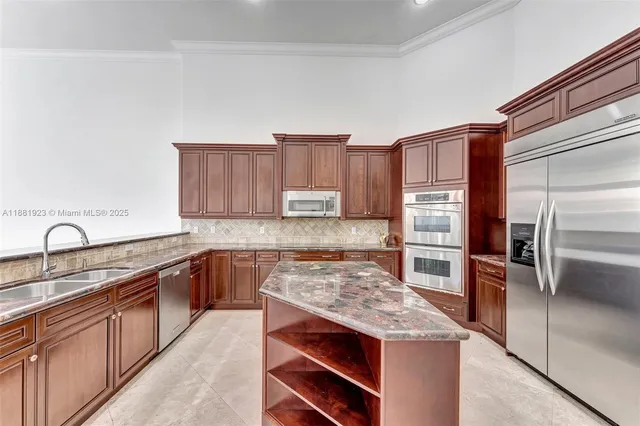 a kitchen with stainless steel appliances granite countertop a stove sink and cabinets