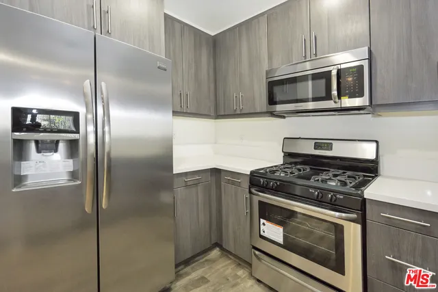a kitchen with stainless steel appliances granite countertop a stove and a microwave