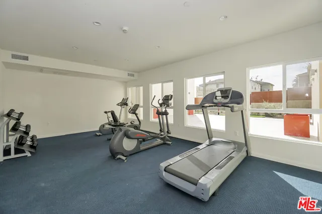 a room with gym equipment and view of living room