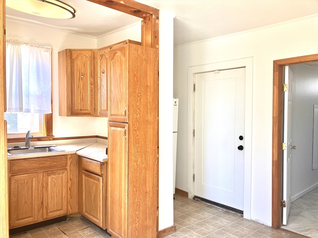 4 Sisson Terrace, Unit 1 Lynn, MA 01902 - Photo 5 of 16 a view of a kitchen with a stove top oven a sink and a window