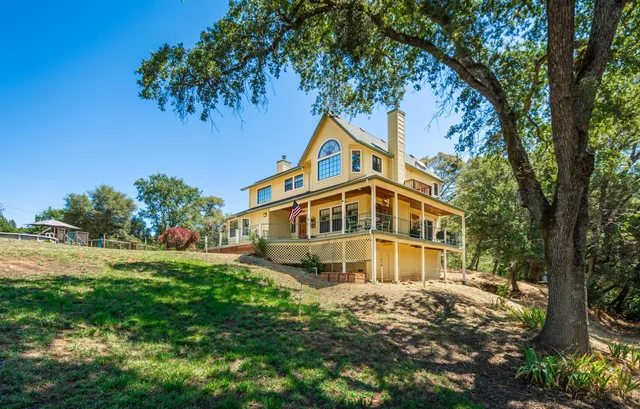 a big house with lots of trees and plants in the background