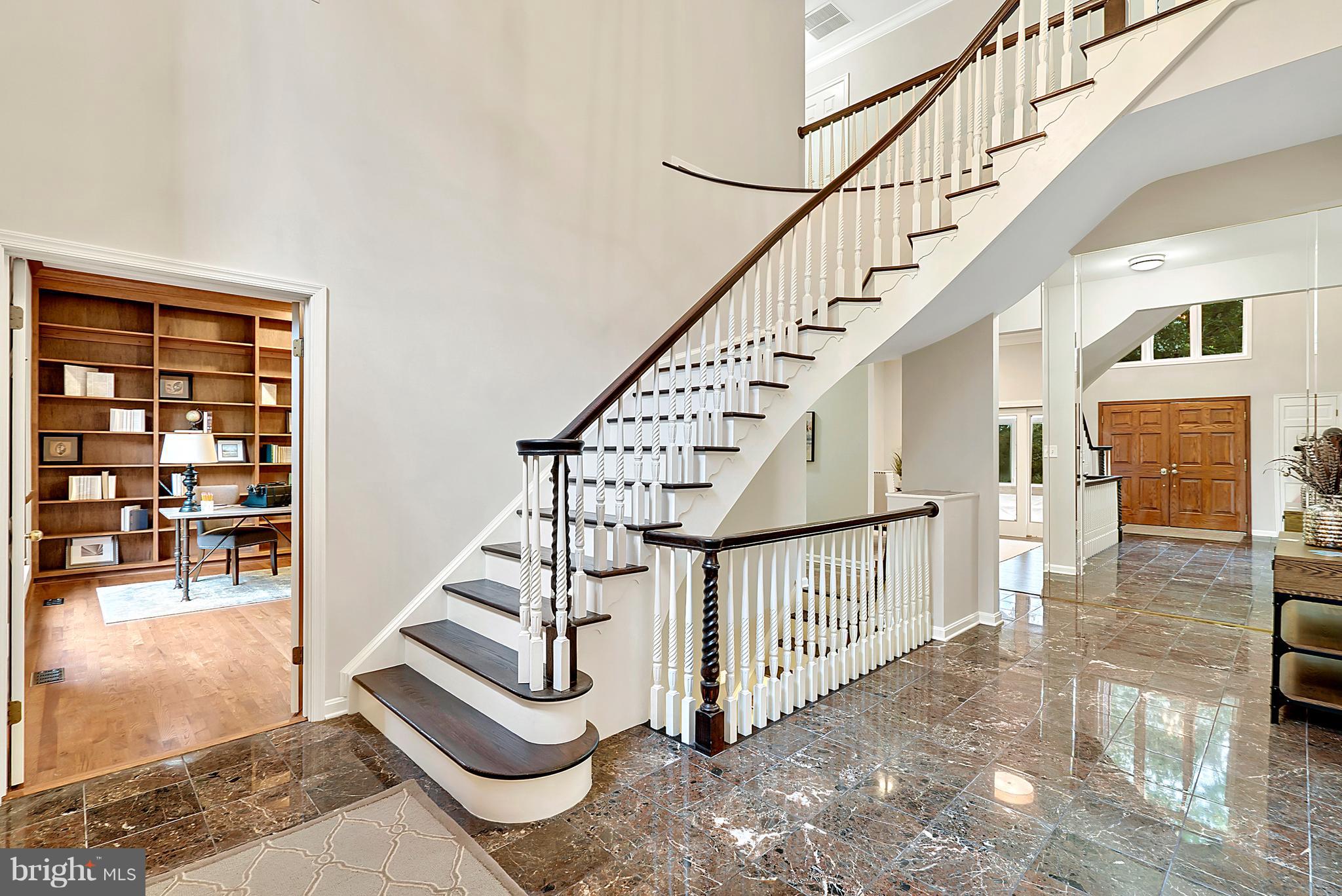 Gracious foyer with dramatic curved staircase.