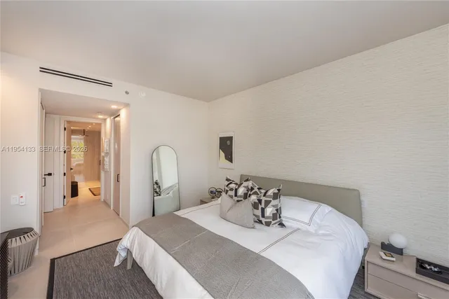 a bedroom with a bed and a mirror on dresser