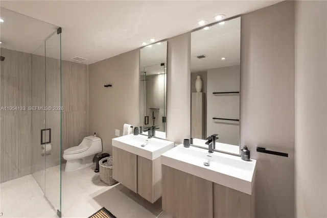 a bathroom with a double vanity sink mirror and toilet