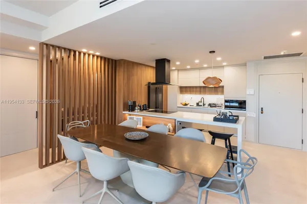 a kitchen with a table chairs and a refrigerator