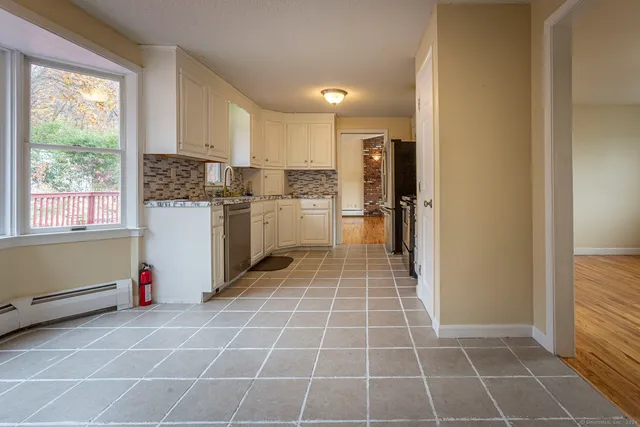 a kitchen with a white cabinets and a window